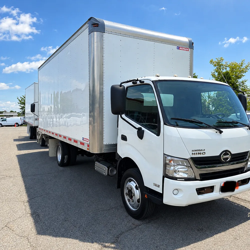 A clean white First Knock Moving box truck parked in the sun
